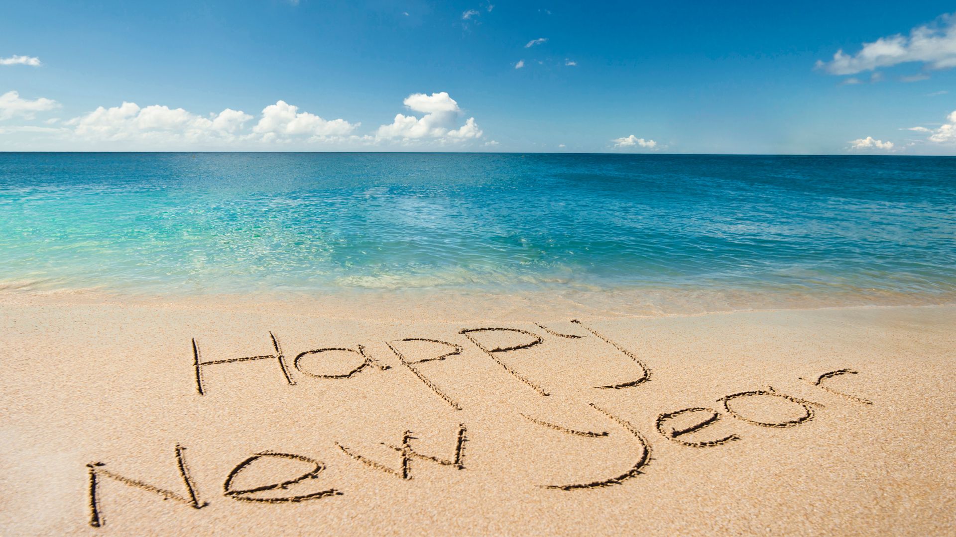 Happy New Year written in the sand