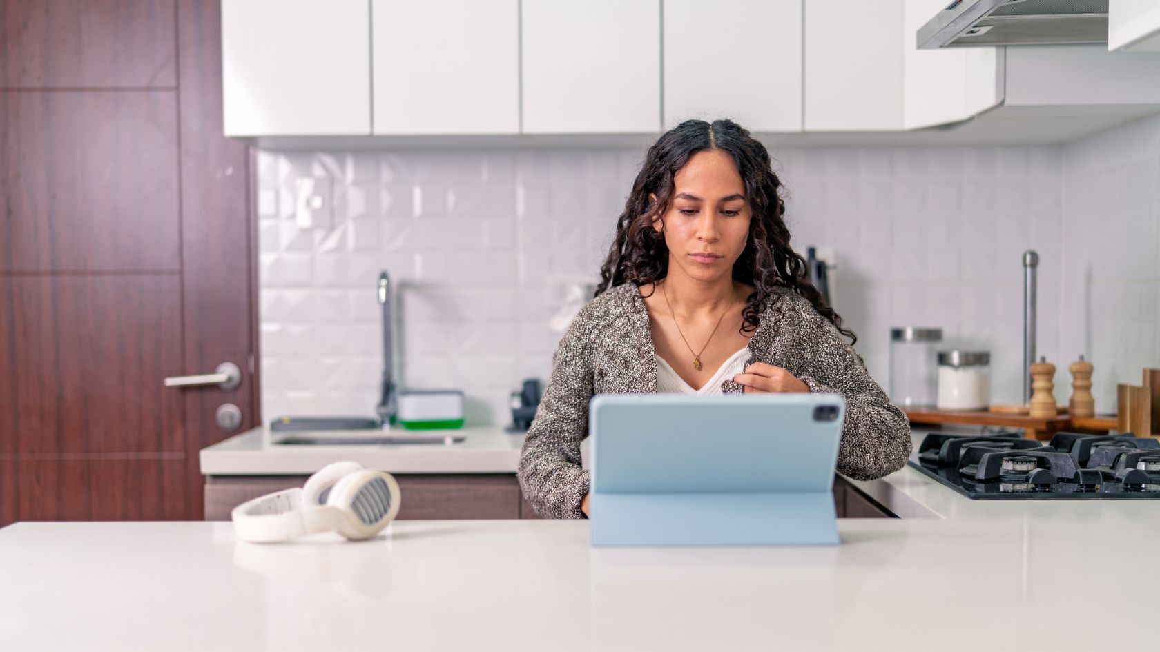 Student at kitchen counter with tablet